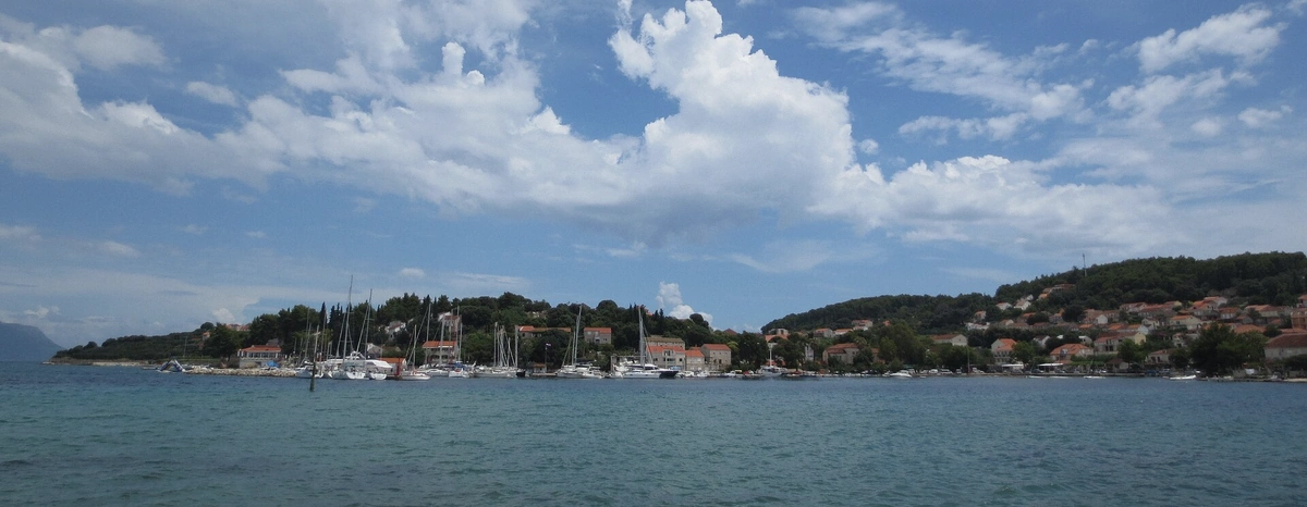 View across calm water to the Lumbarda shoreline of Korcula in Croatia on a soft-season morning