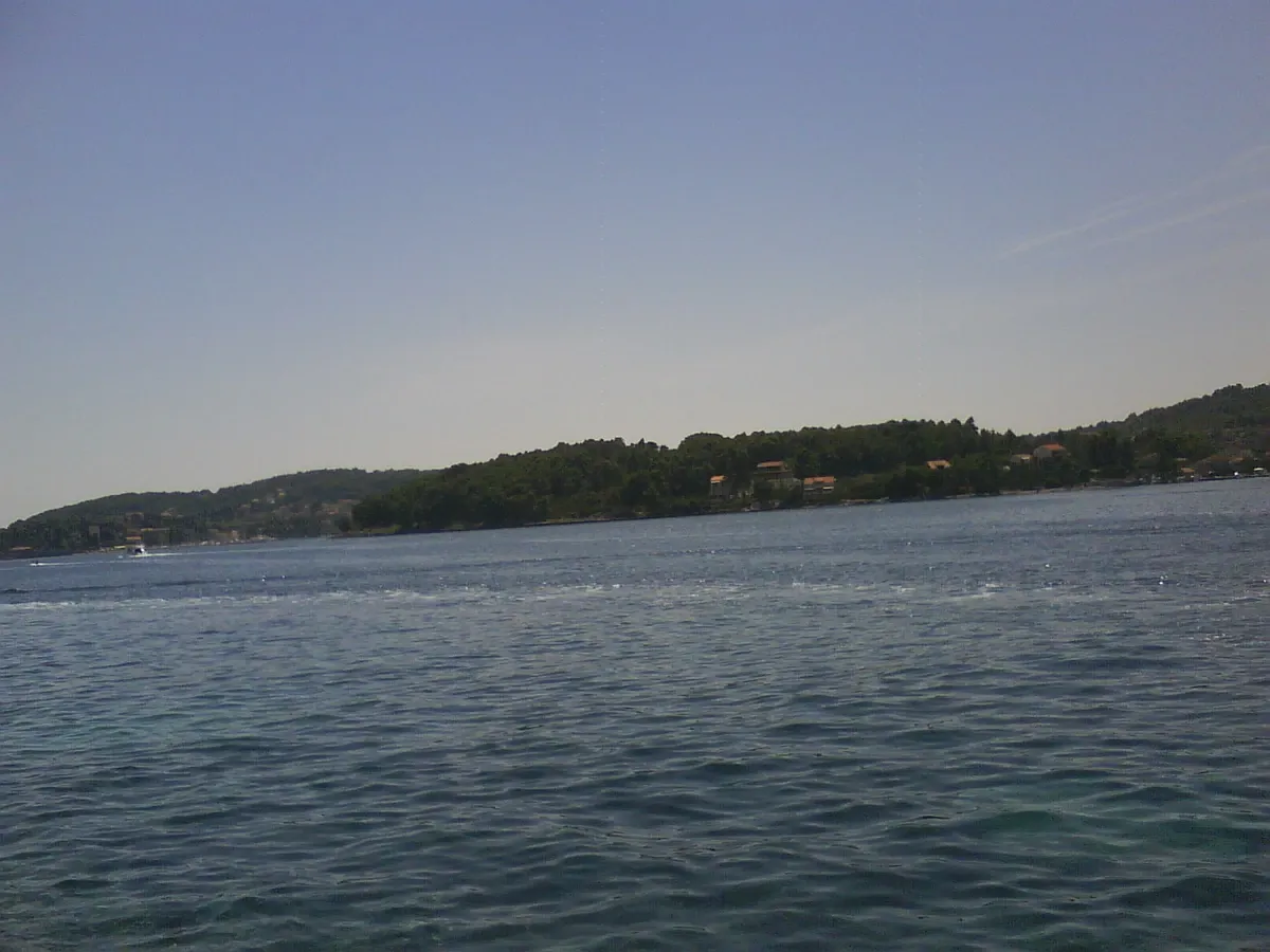 Calm bay and green shoreline seen from the water on a swim stop near Korcula in Croatia