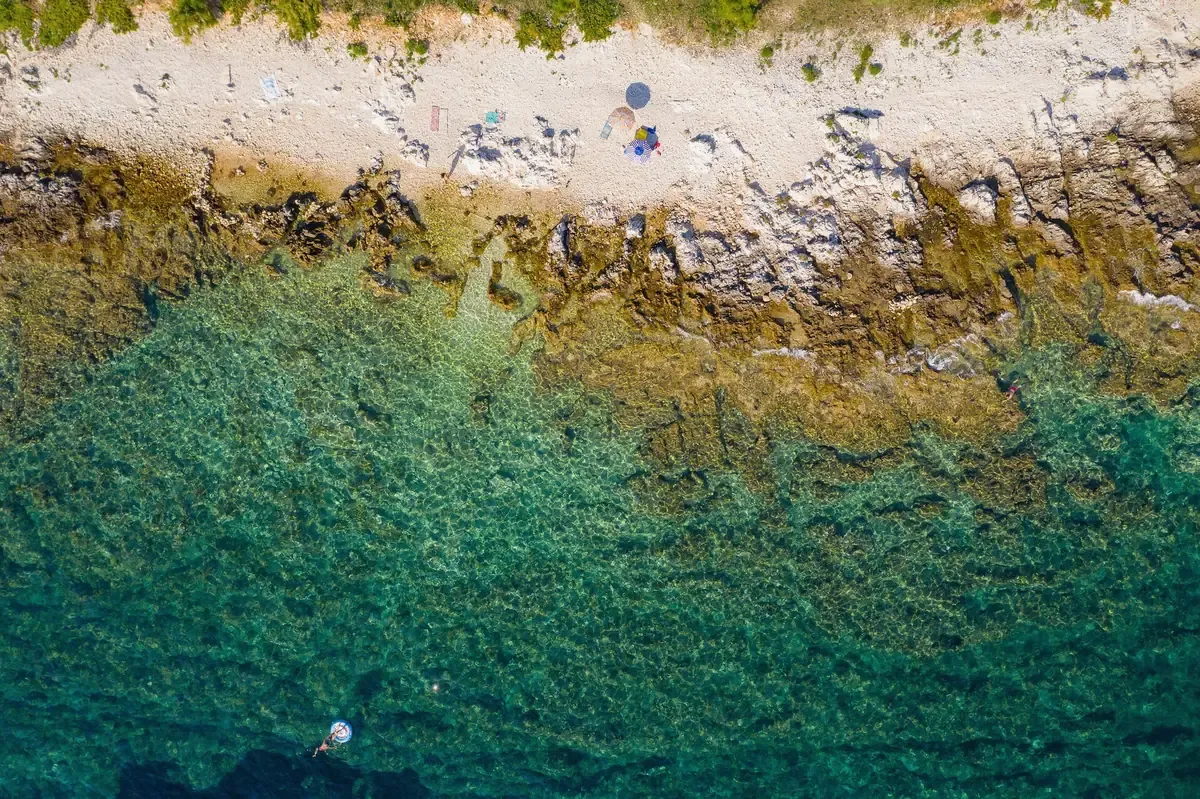 Clear turquoise shallows over pale rock seen from above, the water snorkelled on the Korcula island snorkeling adventure
