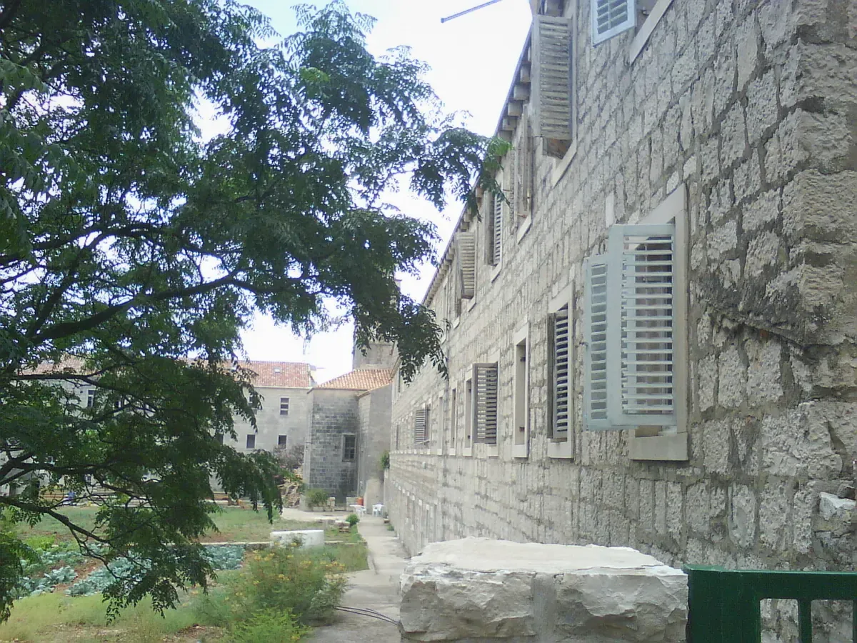 Stone monastery building shaded by trees on Badija island near Korcula in Croatia
