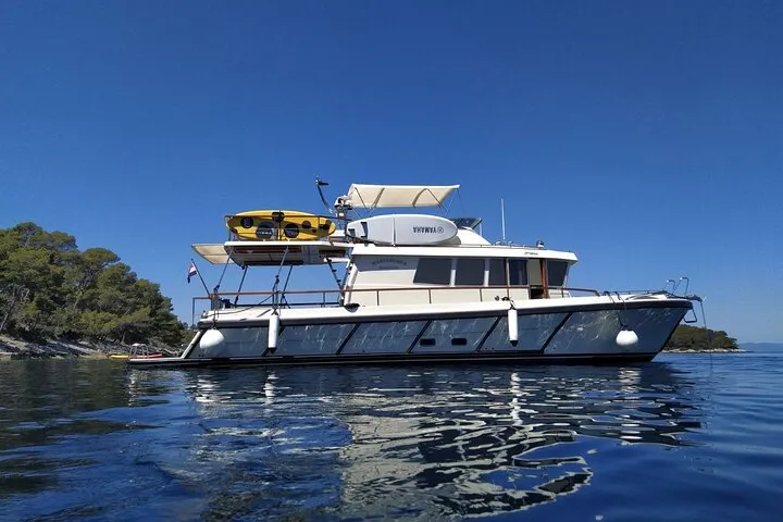 Travellers snorkelling clear blue water beside a white motor yacht on the Korcula Island snorkeling adventure with shipwreck and lunch